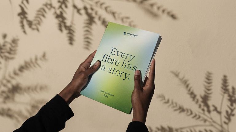 Hands holding the printed CmiA annual report