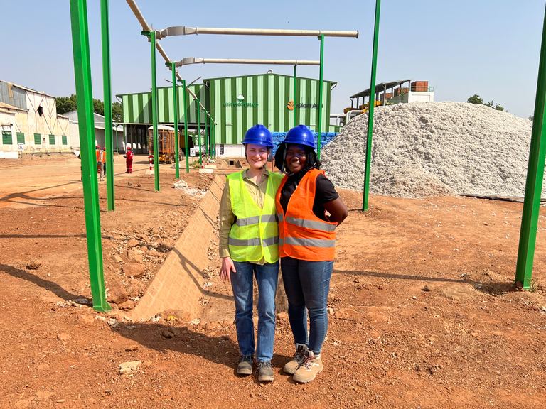 Two workers in high-visibility vests at a cotton ginnery