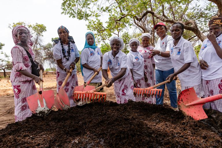 Women working together with rakes on a field